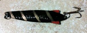Lures null Cuiller ondulante, 12 gr ( noire bandes dorées, aillettes rouges). Lures null Cuiller ondulante, 12 gr ( noire bandes dorées, aillettes rouges).